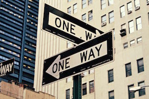 two street signs pointing in opposite designs; read "One Way"